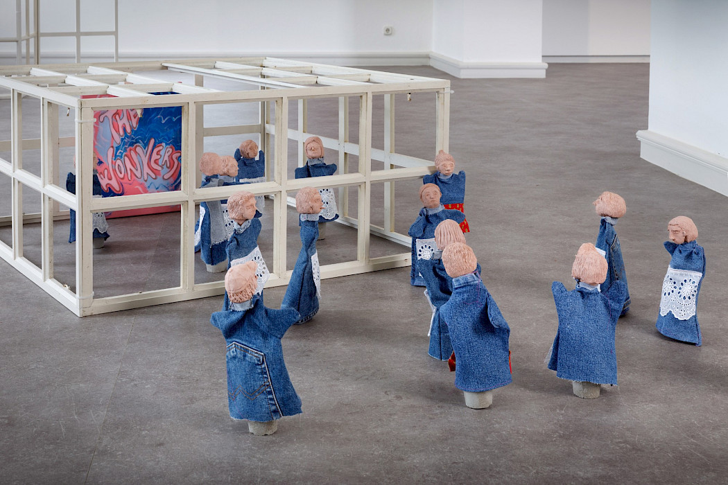 Camille Tsvetoukhine: Haus der Illusion, 2025 Fensterrahmen, Marionetten aus gebranntem rotem Sandstein und Jeansstoff, 80 × 80 × 37 cm (Foto: Clemens Mayer)